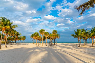 Crandon Park Key Biscayne 'de, bulutlu bir gökyüzünün altında gün batımında. Florida, ABD