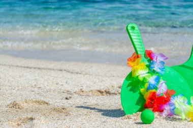 Kumsal raketleri ve deniz kenarındaki Hawaii kolyesi.