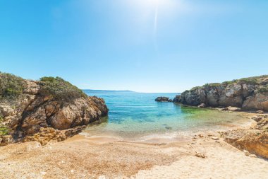 İtalya, Sardunya 'da parlayan güneşin altında kayalar ve kum