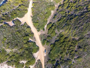 İtalya, Sardinya 'da toprak bir yolda bir adamın arabasının yanında görüntüsü.