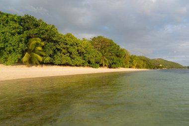 Günbatımında Anse Citron üzerinde kara bulutlar. Praslin Adası, Seyşeller