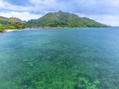 Bulutlu bir günde Anse Madge sahilinin havadan görünüşü. Praslin Adası, Seyşeller