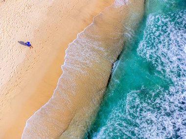 Takamaka sahilinde deniz kenarında bir adamın hava görüntüsü. Mahe Adası, Seyşeller