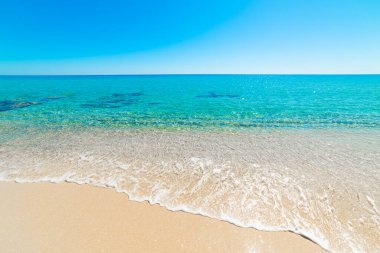 Güneşli bir günde turkuaz suyu ve beyaz kumlu bir sahil. Sardunya, İtalya