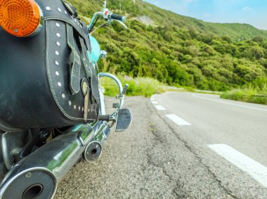 Köy yolunun kenarına park edilmiş klasik bir motosikletin deri eyer çantasını kapat.
