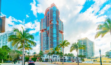 Miami sahilinde bulutlu bir gökyüzünün altında gökdelenler ve palmiye ağaçları. Florida, ABD