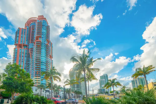 Miami Plajı 'nda bulutlu bir gökyüzü altında modern gökdelenler ve palmiyeler. Florida, ABD