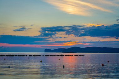 Gün batımında Capo Caccia üzerinde bulutlu bir gökyüzü. Sardunya, İtalya