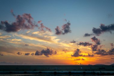 Gün batımında denizin üzerinde dramatik bir gökyüzü. Sardunya, İtalya