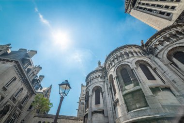 Parlayan güneşin altında dünyaca ünlü Sacre Coeur katedrali. Paris, Fransa
