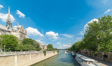 Notre Dame Katedrali güneşli bir günde Seine nehrinin kıyısında. Paris, Fransa