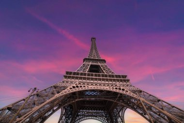 Günbatımında dünyaca ünlü Eyfel Kulesi 'nin üzerinde pembe gökyüzü. Paris, Fransa