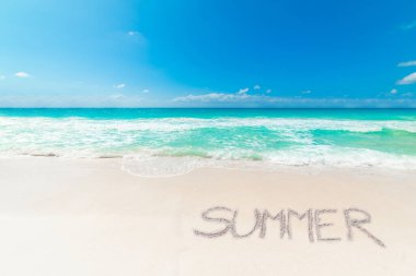 Güneşli bir günde kumsalda yazılan Summer ile tropik bir plaj.