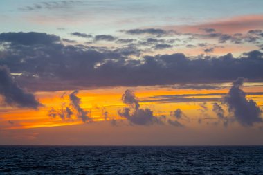 Gün batımında denizin üzerinde dramatik bir gökyüzü. Sardunya, İtalya
