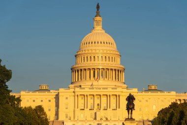 Gün batımında açık bir gökyüzünün altında meclis binası. Washington D.C., ABD