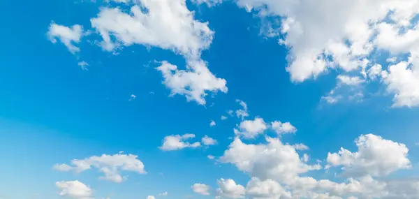 White soft clouds in the blue sky on a sunny day
