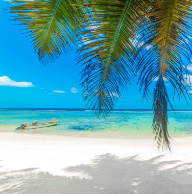 Güneşli bir günde tropik bir sahile demirlemiş küçük bir tekne. Seyşeller, Hint Okyanusu, Afrika