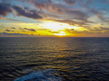 Gün batımında denizin üzerinde dramatik bir gökyüzünün havadan görünüşü