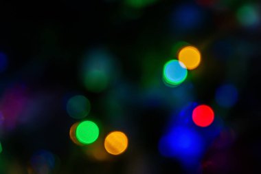 Bokeh efektli siyah bir arkaplanda renkli ışıklar