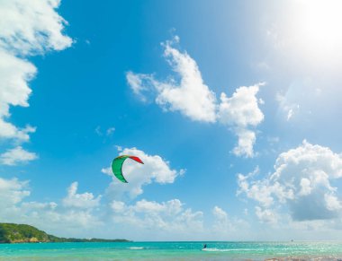 Guadeloupe, Karayip Denizi 'nde parlayan güneşin altında uçurtma sörfçüsü