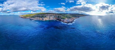 Bulutlu bir günde, kayalık bir sahil kenarındaki mavi denizin havadan görünüşü. Sardunya, İtalya