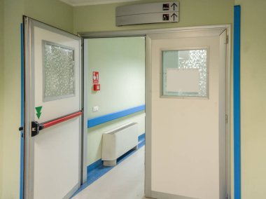 Boş bir koridorda kırmızı acil durum kolu olan hastane koğuşunun kapısını aç.