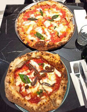 Yukarıdan görünen bir restoranda iki pizza.