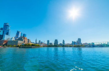Arka planda Manhattan 'ın olduğu Hudson nehrinin üzerinde güneş parlıyor. New York City, ABD