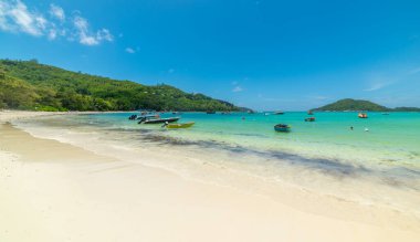 Mavi gökyüzünün altındaki tropik bir sahilde tekneler. Seyşeller, Hint Okyanusu