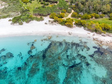 Lu Impostu sahilinde turkuaz su ve beyaz kum, yukarıdan görüldü. Sardunya, İtalya