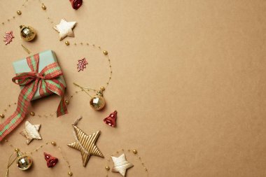 Kahverengi arka planda Noel süsü ve hediye kutusu. Noel kış dekorasyonu. düz alan, üst görünüm, kopyala boşluk