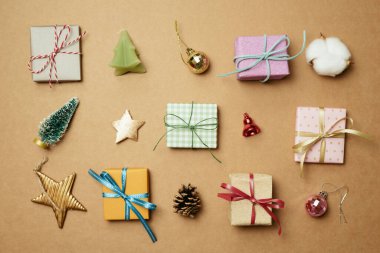 Kahverengi arka planda Noel süsü ve hediye kutusu. Noel kış dekorasyonu. düz yatış, üst görünüm