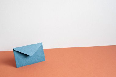 Navy color envelope on red table. white wall background. minimalism, copy space