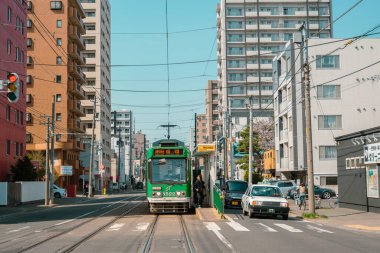 Sapporo, Hokkaido, Japonya - 25 Nisan 2023: Sapporo şehir sokağı ve eski tramvay