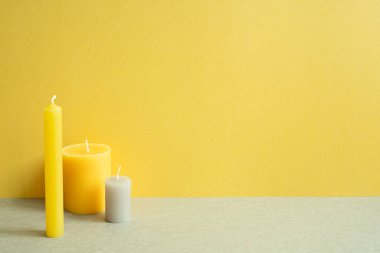 Gri masada çok az mum var. sarı duvar arkaplanı