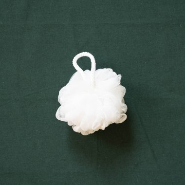 Banyo beyazı duş havlusu yeşil kumaş arka planda izole edilmiş. Üst görünüm, boşluk kopyala