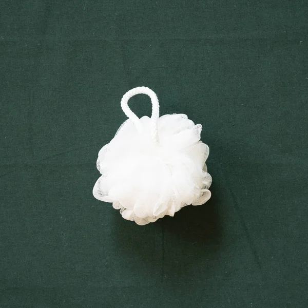 Banyo beyazı duş havlusu yeşil kumaş arka planda izole edilmiş. Üst görünüm, boşluk kopyala