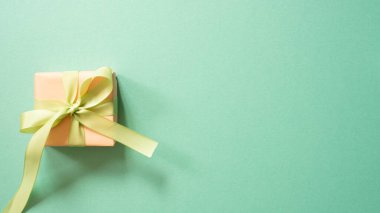 Yeşil arkaplanda izole edilmiş mercan hediye kutusu. Üst görünüm, boşluk kopyala