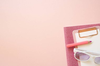 Pembe defter, dosya, renkli kalem, pembe masa arkasında gözlük. Düz konum, üst görünüm, kopyalama alanı. çalışma alanı