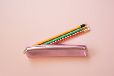 Pembe arka planda yazım malzemesi olan pembe kalem kutusu. en üstteki görünüm
