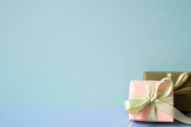 Mercan ve haki rengi hediye paketi mavi masada. nane yeşili arkaplan