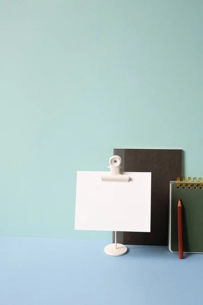 Notebook, memo pad, colored pencil on blue desk. mint green background. study and workspace