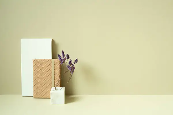 Notebook and diary, vase of dry flower on desk. khaki beige background