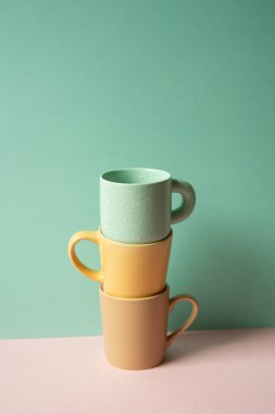 Kupa yığını pembe masanın üzerinde. nane yeşili duvar arkaplanı