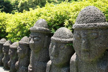 Dol hareubang taşı büyükbaba heykeli Jeju Adası, Kore 'deki Cheonjiyeon Şelalesinde.