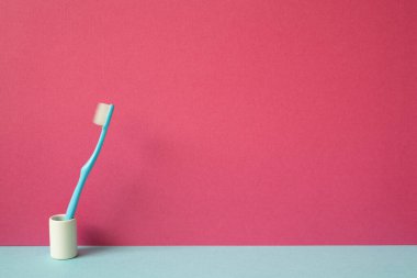 Diş fırçası Skyblue rafında duruyor. pembe duvar arkaplanı