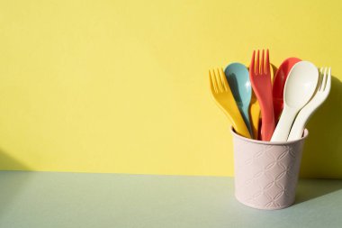 Mutfak aletleri. Çatal çatal bıçak gri masada. sarı duvar arkaplanı