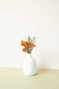 Masada beyaz, kuru bir çiçek vazosu var. beyaz fildişi arkaplanı