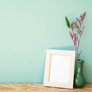 Ahşap fotoğraf çerçevesi ve ahşap rafta kurumuş çiçek vazosu. nane duvarı arkaplanı