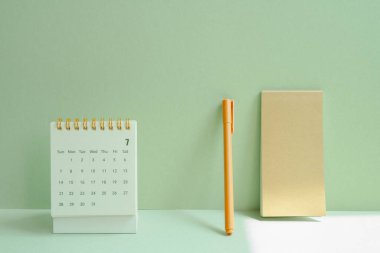 Takvim ve not defteri, takvim için kalem, iş, yeşil masa arkaplanındaki tatil planı